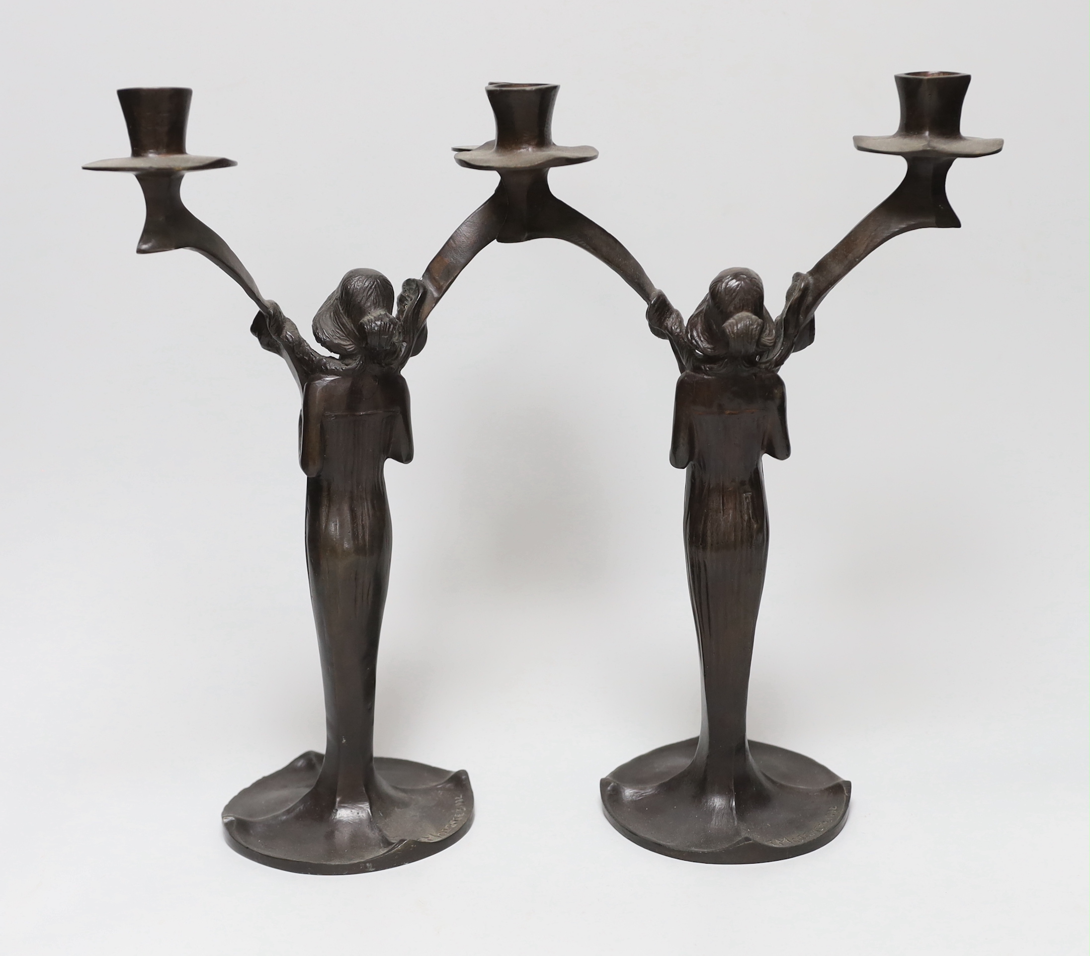 After Jules Moigniez (1835-1894) - a pair of bronze two branch candelabra, signed, dated 1902, 34cm high
